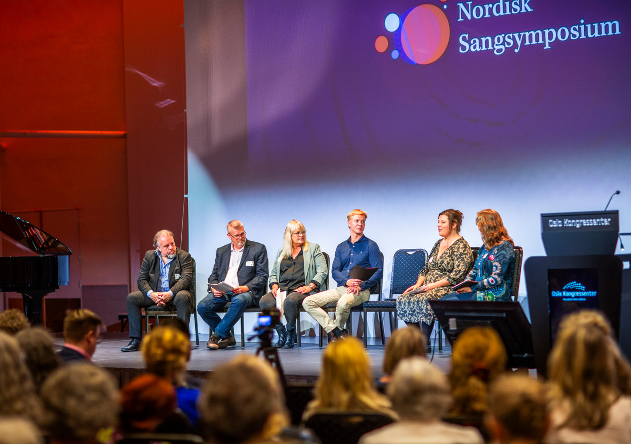 Jarle Flemvåg, midterst i blå skjorte, under paneldebat ved Nordisk Sangsymposium i 2023. Blandt andet i selskab med Lea Wierød Borčak, nr. to fra højre, og finske Patrik Karlsson fra Musik i Norden, nr. to fra venstre.
